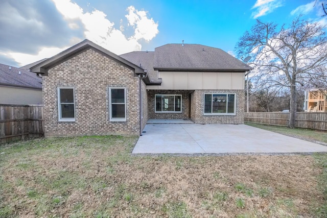 back of property with a yard and a patio area