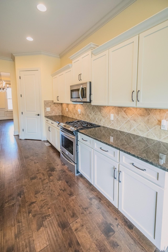 kitchen with ornamental molding, stainless steel appliances, dark hardwood / wood-style floors, and white cabinets