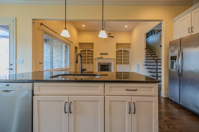 kitchen with sink, crown molding, white cabinetry, dark stone countertops, and stainless steel appliances