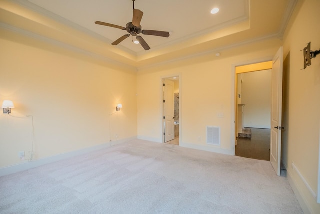 empty room with light carpet, crown molding, a raised ceiling, and ceiling fan