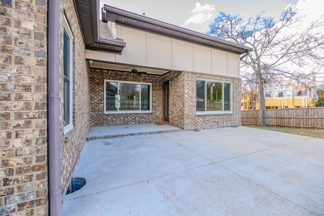 rear view of house with ceiling fan and a patio