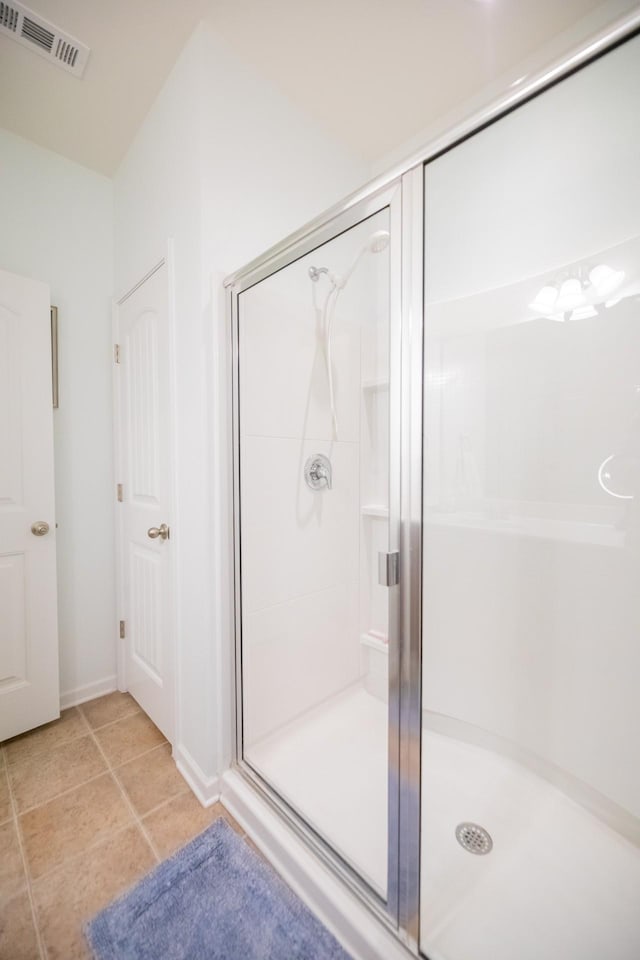 bathroom with tile patterned flooring and a shower with shower door