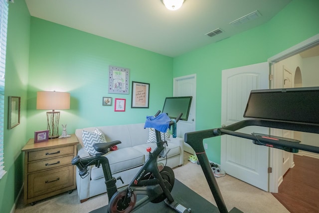 exercise room with light colored carpet