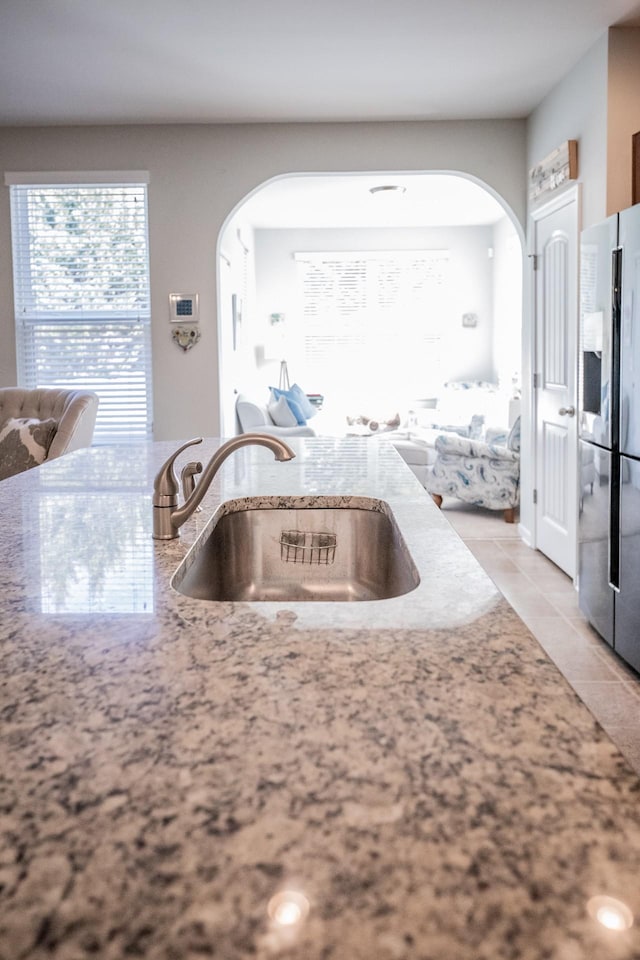 kitchen featuring sink, light tile patterned flooring, and stainless steel fridge with ice dispenser