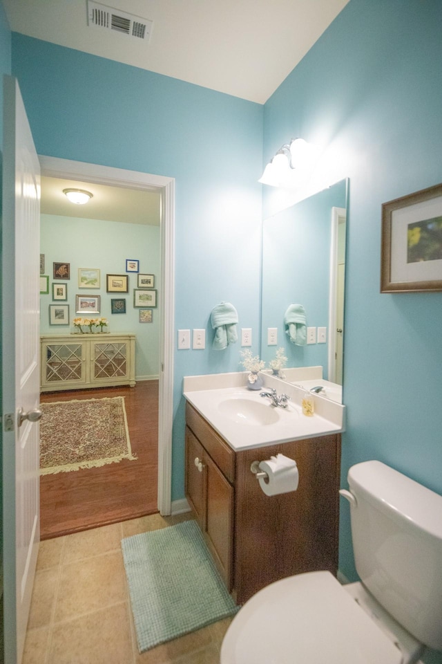 bathroom with toilet, tile patterned flooring, and vanity