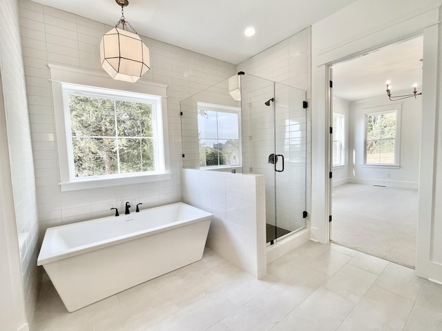 bathroom featuring plenty of natural light, tile patterned floors, and plus walk in shower