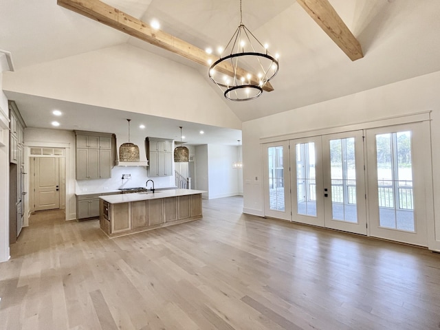 kitchen with light hardwood / wood-style floors, hanging light fixtures, a large island, a chandelier, and beam ceiling