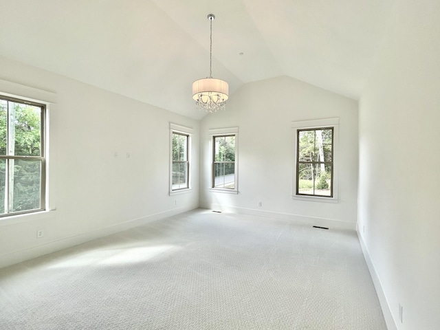 unfurnished room featuring a chandelier, light colored carpet, and lofted ceiling