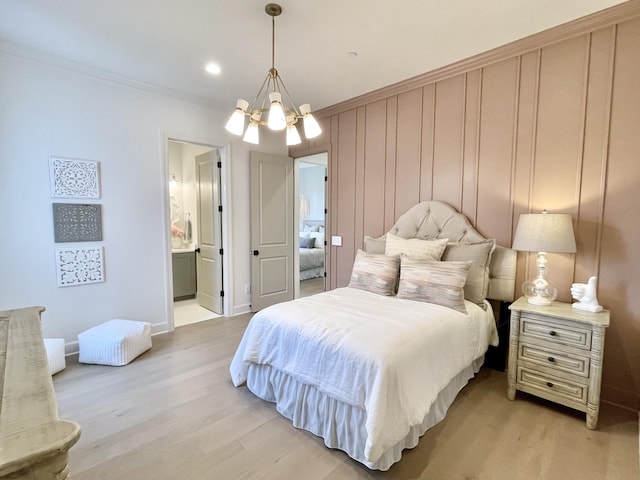 bedroom with light hardwood / wood-style floors, connected bathroom, ornamental molding, and a chandelier