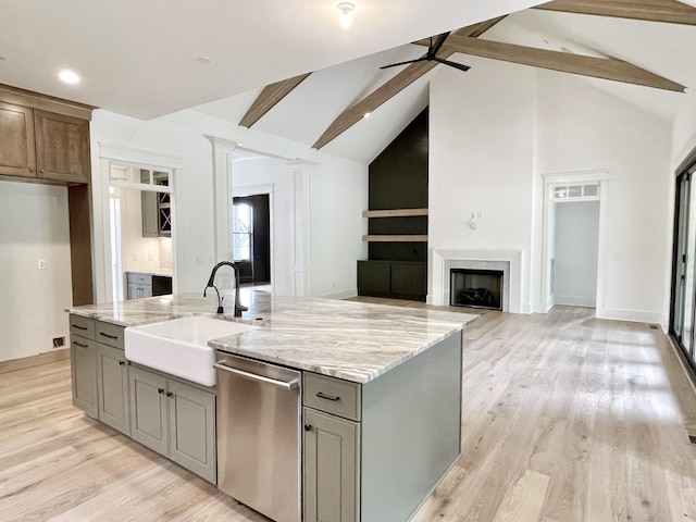 kitchen featuring sink, dishwasher, a kitchen island with sink, and lofted ceiling with beams