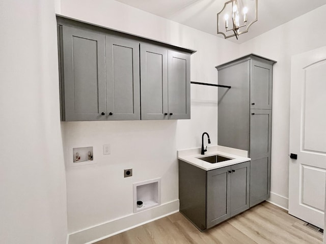 washroom featuring cabinets, sink, washer hookup, hookup for an electric dryer, and light hardwood / wood-style flooring