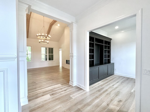 hall with crown molding, decorative columns, light hardwood / wood-style flooring, an inviting chandelier, and lofted ceiling