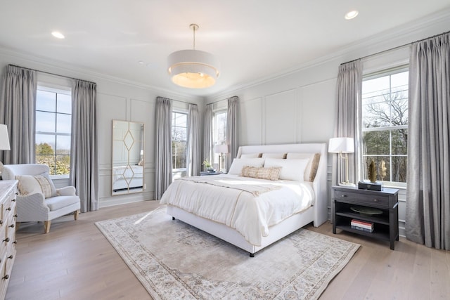 bedroom featuring light wood-type flooring and crown molding