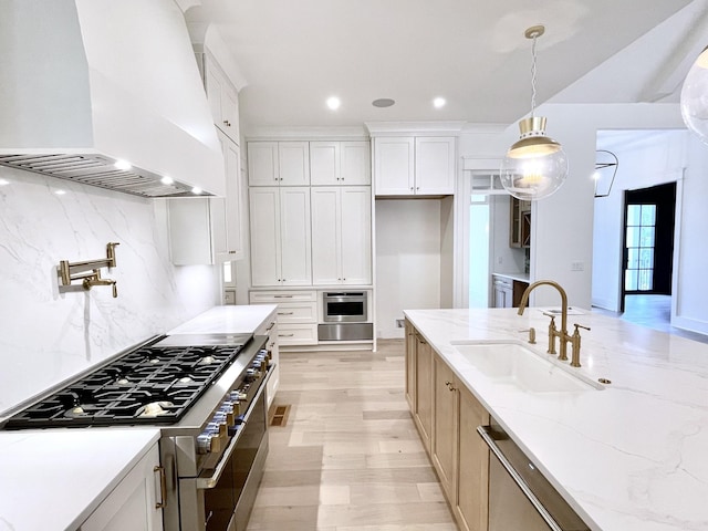 kitchen featuring white cabinetry, light stone countertops, appliances with stainless steel finishes, and custom range hood