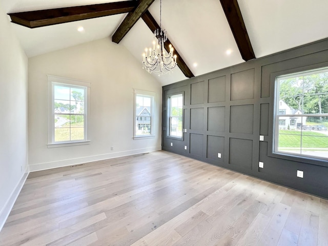 unfurnished room with light hardwood / wood-style floors, beamed ceiling, a chandelier, and a healthy amount of sunlight