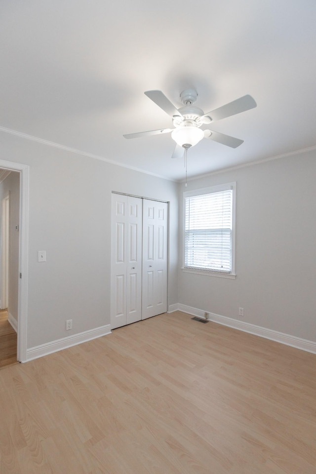 unfurnished bedroom featuring a closet, ceiling fan, light hardwood / wood-style flooring, and crown molding