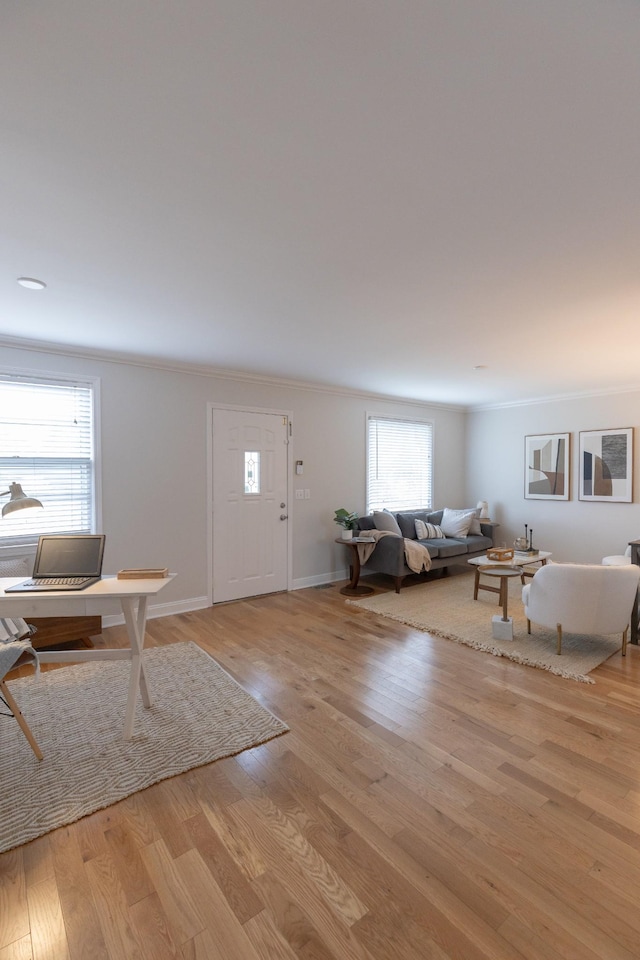 unfurnished living room with ornamental molding and light wood-type flooring