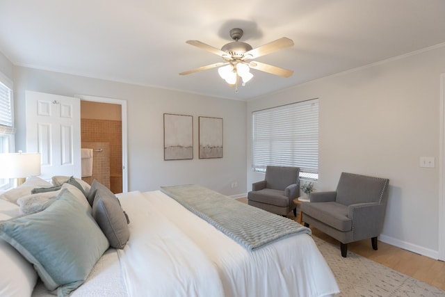 bedroom with ceiling fan, connected bathroom, hardwood / wood-style flooring, and ornamental molding