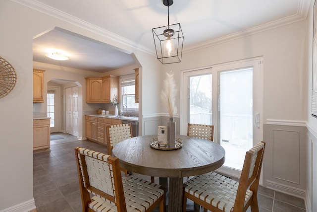 tiled dining area featuring sink and ornamental molding