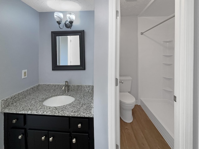 bathroom featuring a textured ceiling, toilet, vanity, and hardwood / wood-style floors