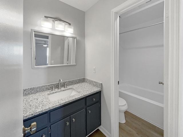 full bathroom featuring shower / bath combination, hardwood / wood-style floors, toilet, and vanity