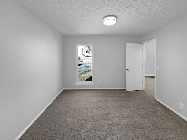 unfurnished room with a textured ceiling and carpet floors