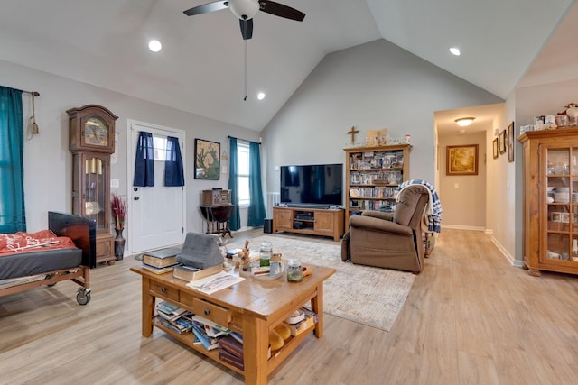 living room with light hardwood / wood-style floors, high vaulted ceiling, and ceiling fan