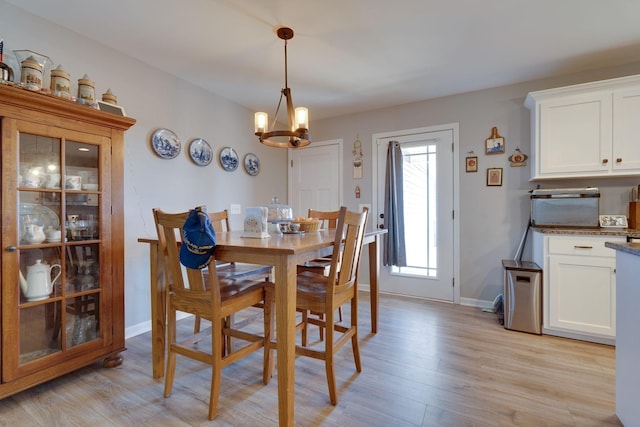 dining area featuring light wood-type flooring and a chandelier