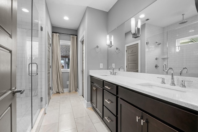 bathroom featuring double vanity, a stall shower, and a sink