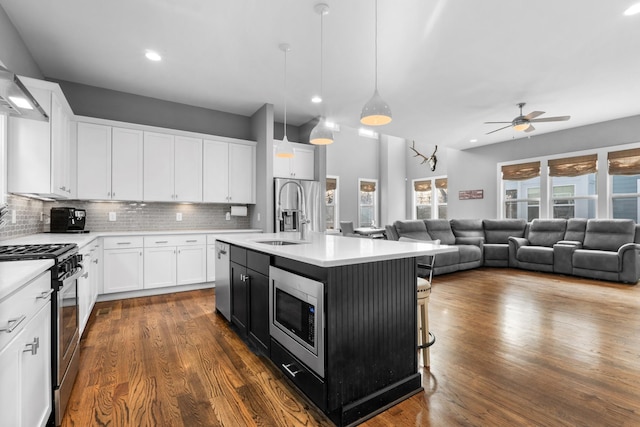 kitchen featuring tasteful backsplash, stainless steel appliances, a sink, and light countertops