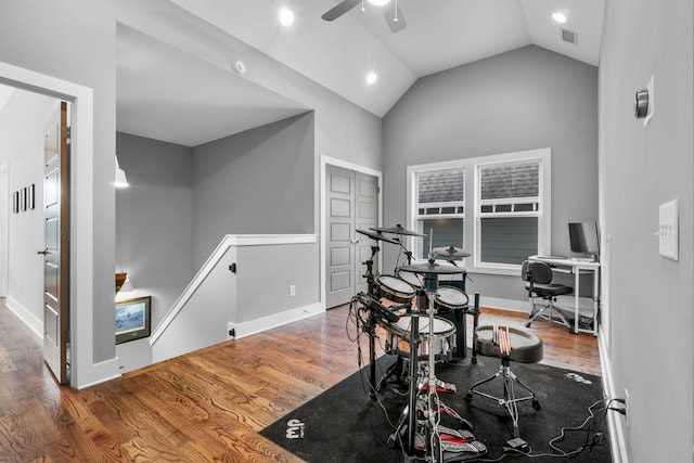 workout area with baseboards, visible vents, lofted ceiling, ceiling fan, and wood finished floors