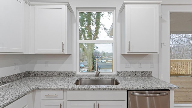 kitchen featuring sink, white cabinetry, light stone counters, and stainless steel dishwasher