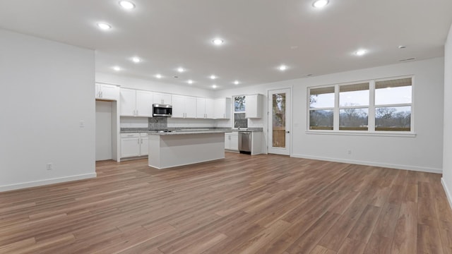 kitchen with a kitchen island, white cabinets, light wood-type flooring, and stainless steel appliances