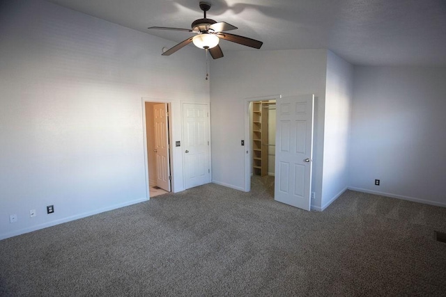 unfurnished bedroom featuring a spacious closet, ceiling fan, and carpet