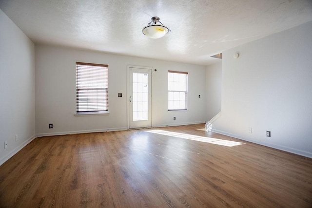 unfurnished room featuring hardwood / wood-style flooring and a textured ceiling