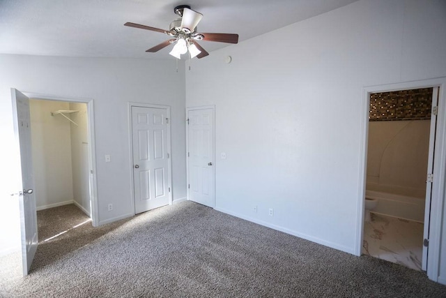 unfurnished bedroom featuring ensuite bathroom, carpet, lofted ceiling, and ceiling fan