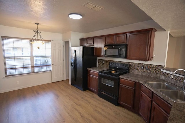 kitchen featuring sink, light hardwood / wood-style flooring, tasteful backsplash, black appliances, and decorative light fixtures