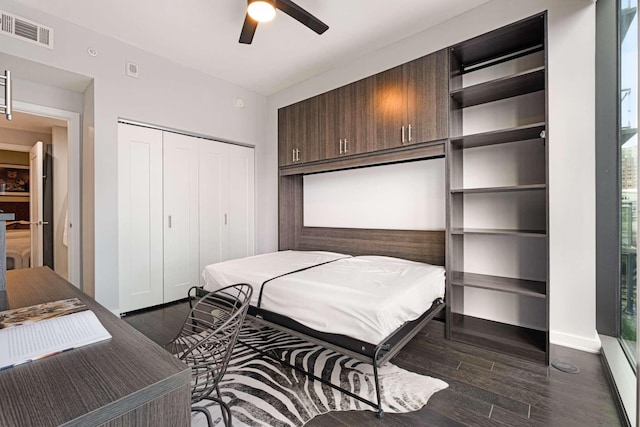 bedroom with a closet, ceiling fan, and dark hardwood / wood-style flooring