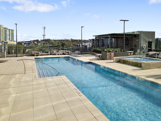 view of swimming pool with a patio area and a community hot tub