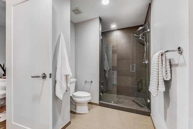 bathroom featuring toilet and a shower with door