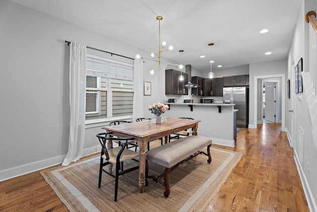 dining room with light hardwood / wood-style flooring and a notable chandelier