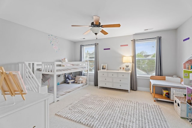 bedroom with light carpet, multiple windows, and ceiling fan