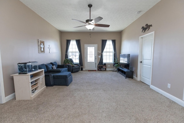 carpeted living room featuring a textured ceiling and ceiling fan