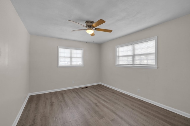 empty room featuring light wood-type flooring, ceiling fan, and plenty of natural light