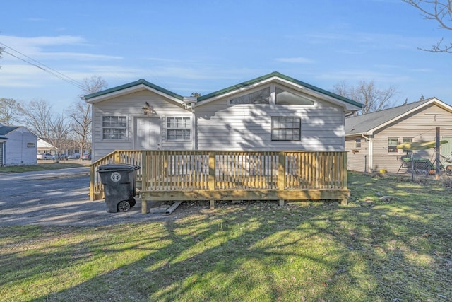 rear view of property with a lawn and a wooden deck