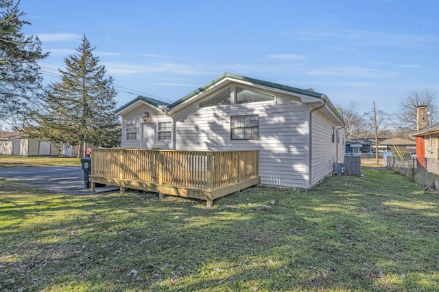 rear view of house with a deck, central AC, and a yard