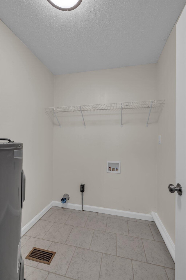 laundry room with a textured ceiling, light tile patterned floors, washer hookup, and electric water heater