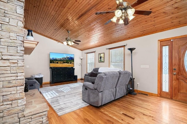 living room featuring wood ceiling, light wood-type flooring, a wood stove, and lofted ceiling