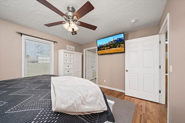 bedroom featuring hardwood / wood-style floors, a textured ceiling, and ceiling fan