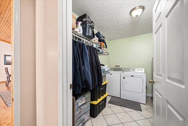 washroom featuring light tile patterned floors, a textured ceiling, and independent washer and dryer